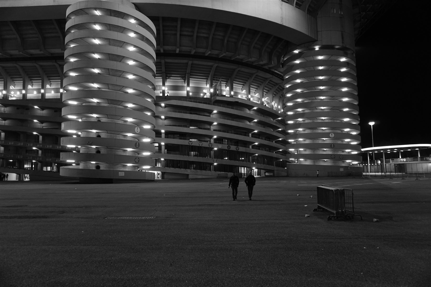 Supporters outside a football stadium at night.